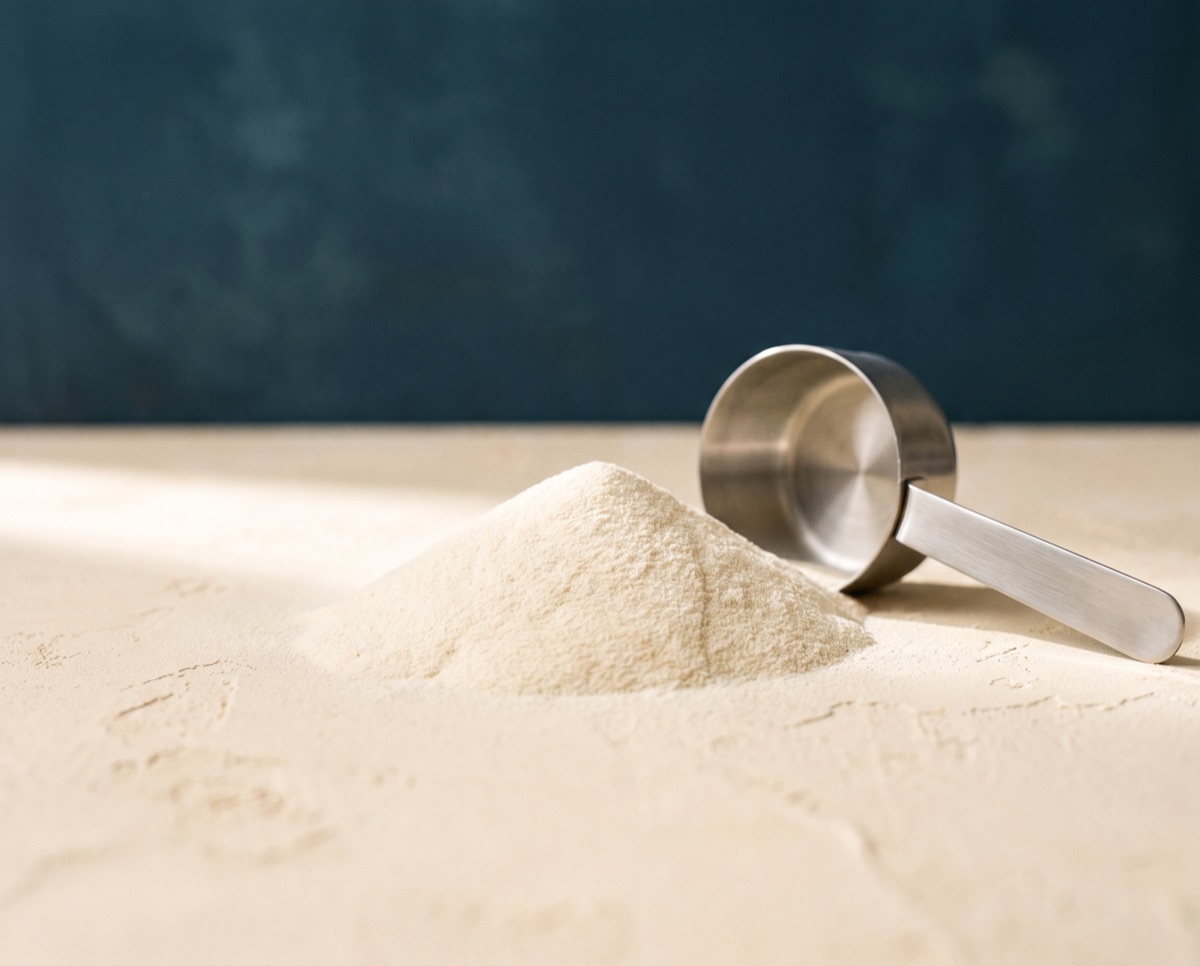 Cream-coloured colostrum powder with a scoop