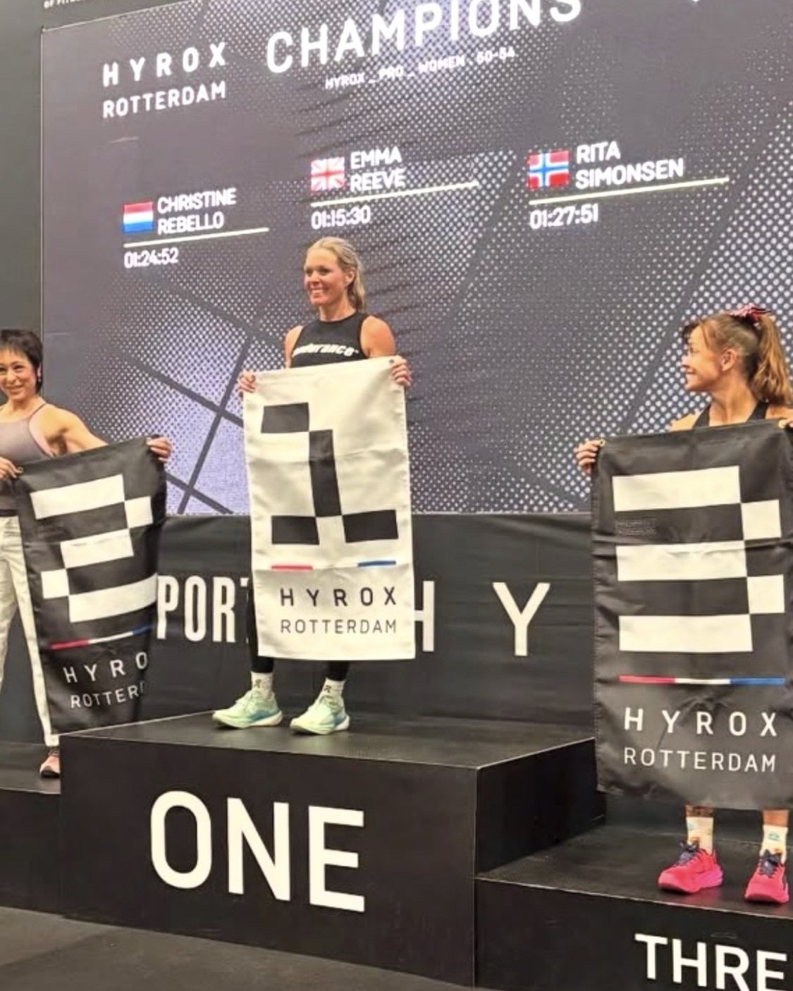 Emma Reeve on the top step of the podium at Hyrox Rotterdam, winning the women's 50-54 pro category in 1:15:30