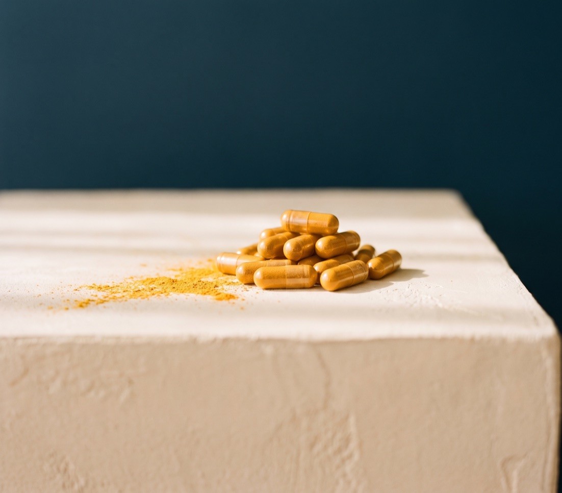 Golden-orange turmeric capsules with turmeric powder
